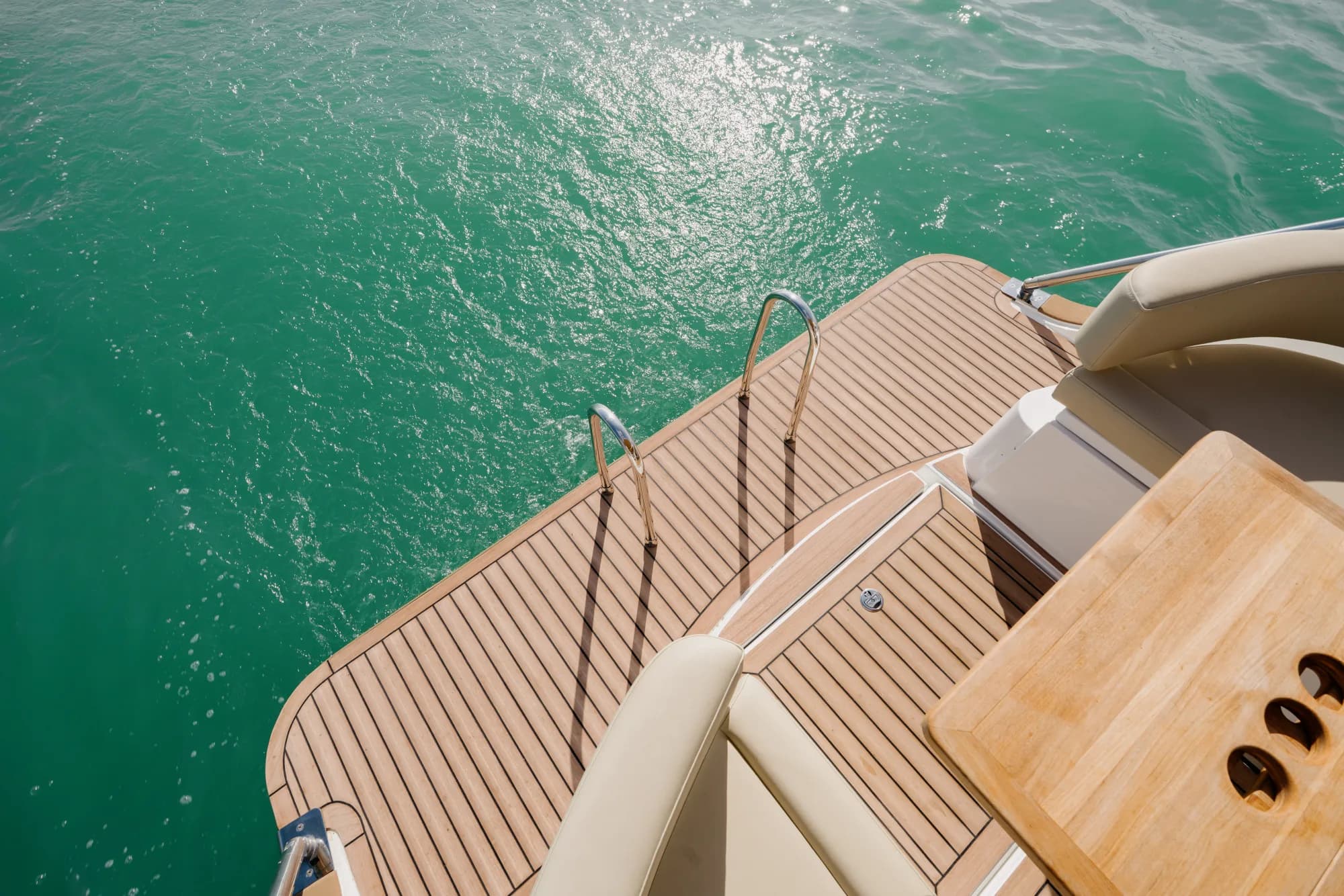 The white-hulled Wia 330 under way, its cream canvas top raised over the open cockpit and tan upholstery, with teak deck trim.