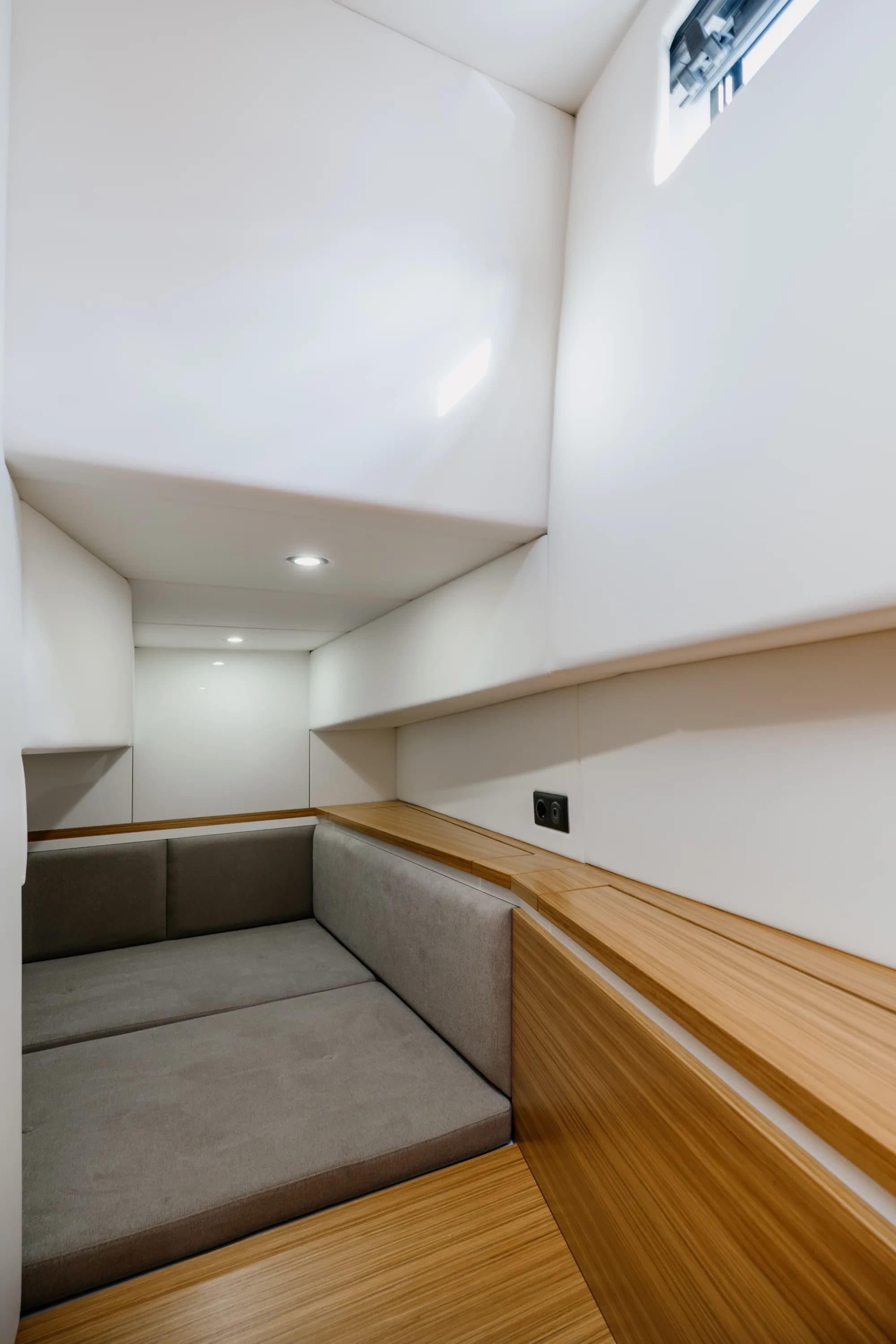The enclosed wheelhouse of the Wia 350: bright orange leather seating, a light oak dinette, a chrome-spoked helm and a touchscreen at the console, wrapped in panoramic windows.