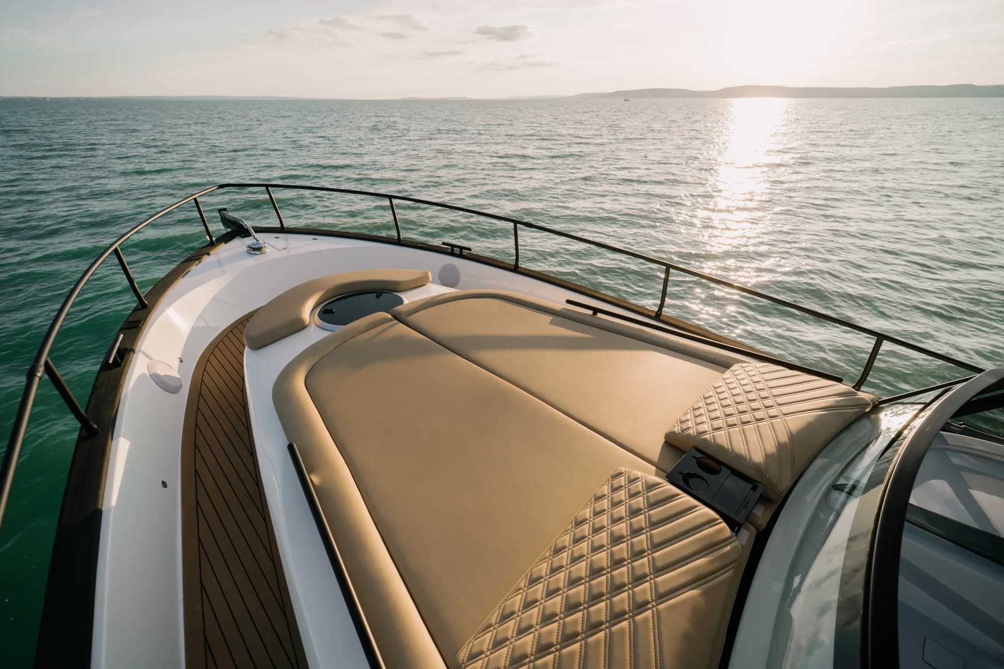 The white-hulled Wia 450 Cabrio under way on the water at dusk, its black canvas top raised over the open cockpit.