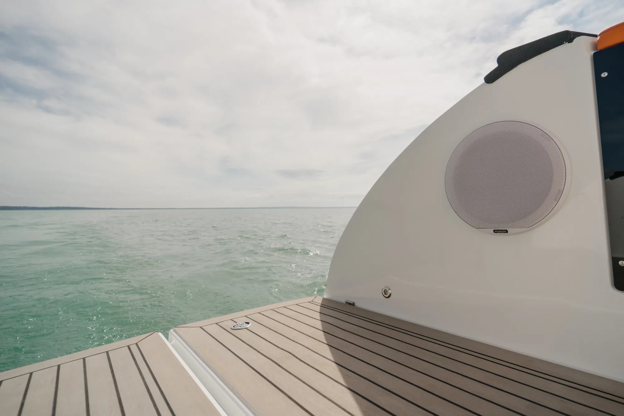 The dark-grey-hulled Wia 450 HardTop under way, its white hardtop over the enclosed helm and orange sunpads on the foredeck.