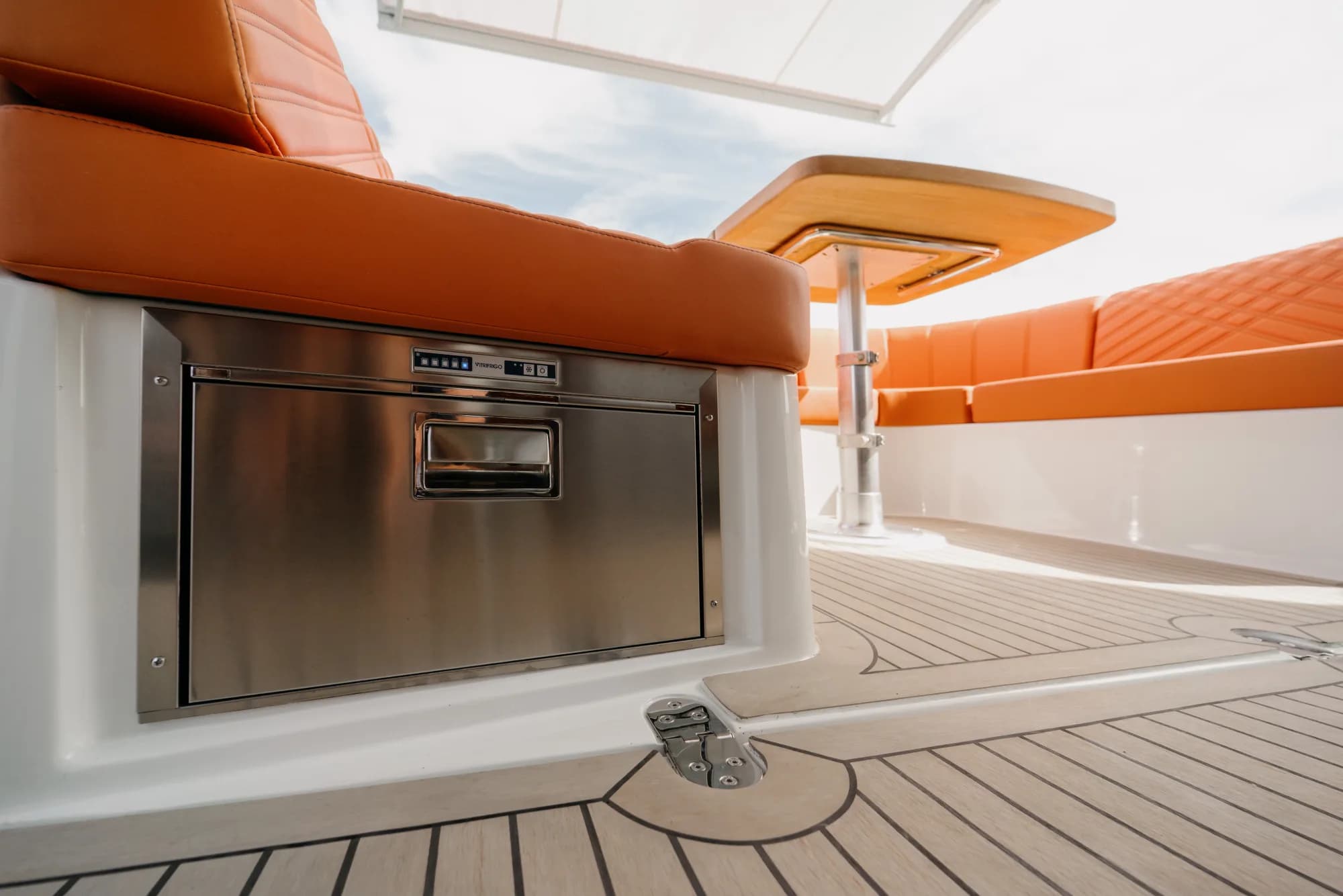 The dark-grey-hulled Wia 450 HardTop under way, its white hardtop over the enclosed helm and orange sunpads on the foredeck.