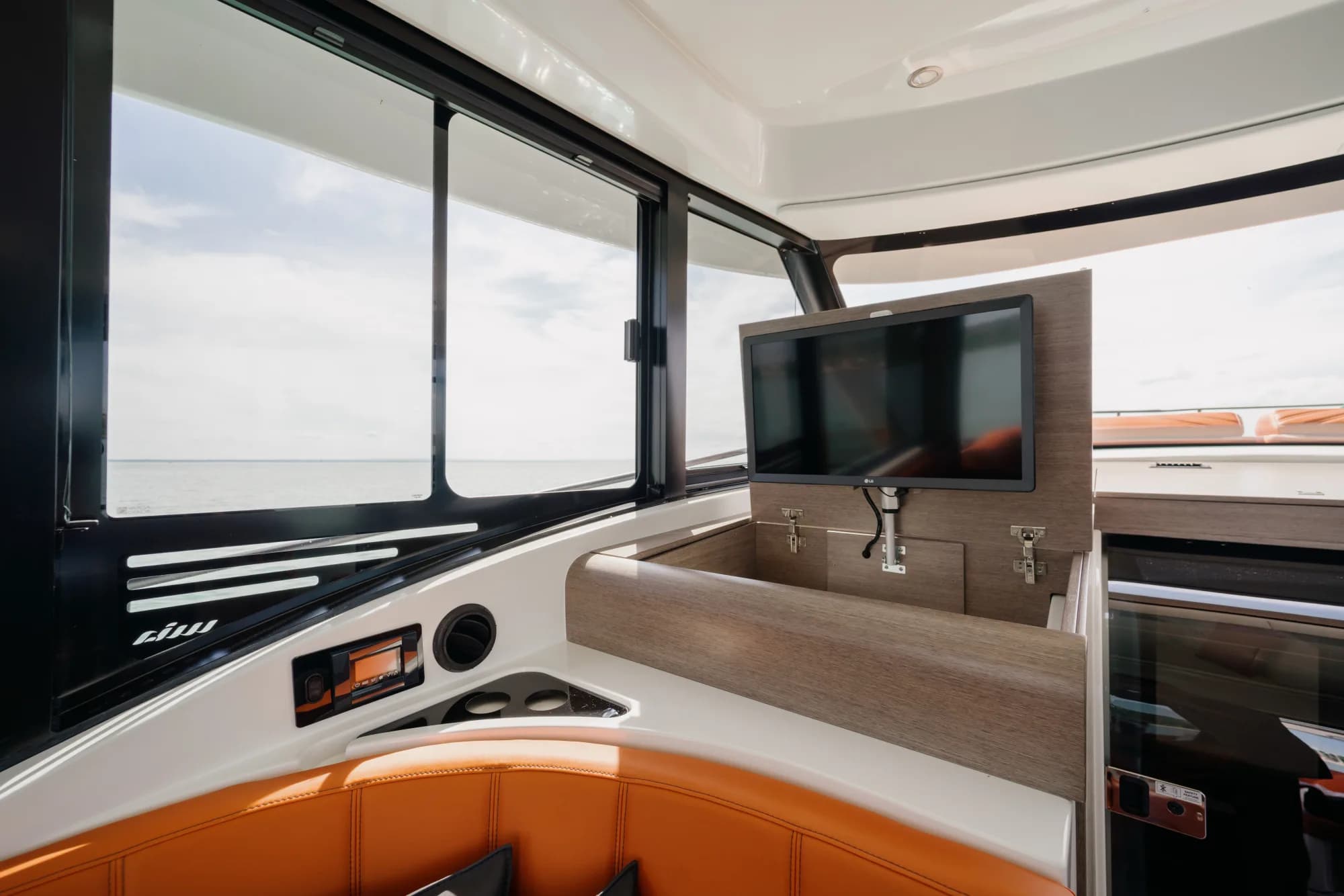The teak-trimmed deck of the Wia 450 HardTop with orange sunpads and stainless rails.