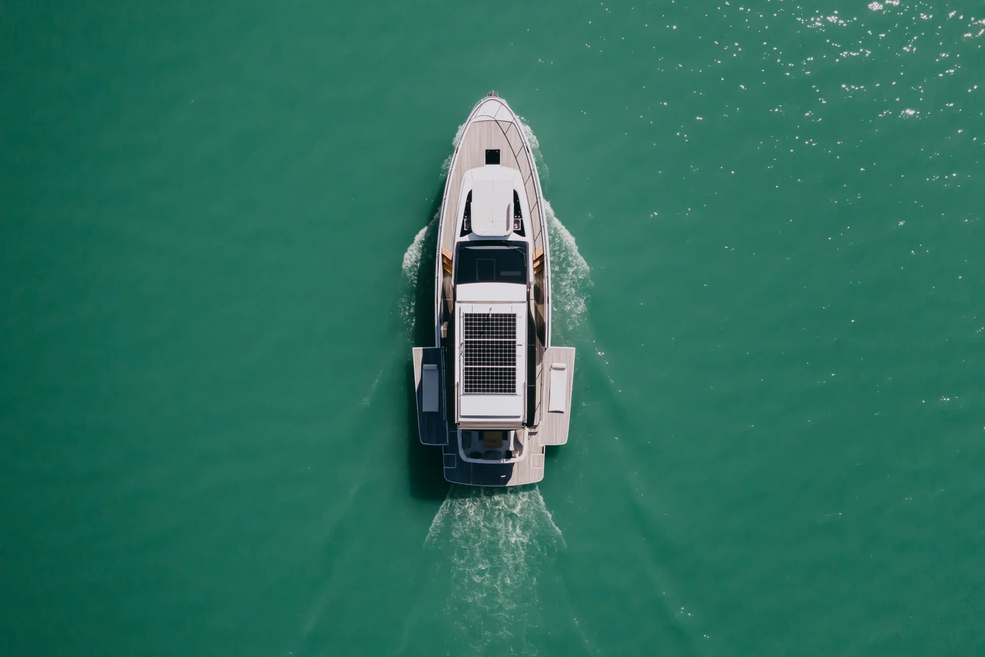 The white-hulled Wia 520 HardTop under way, its dark hardtop with roof solar panels over the enclosed saloon and teak decks.