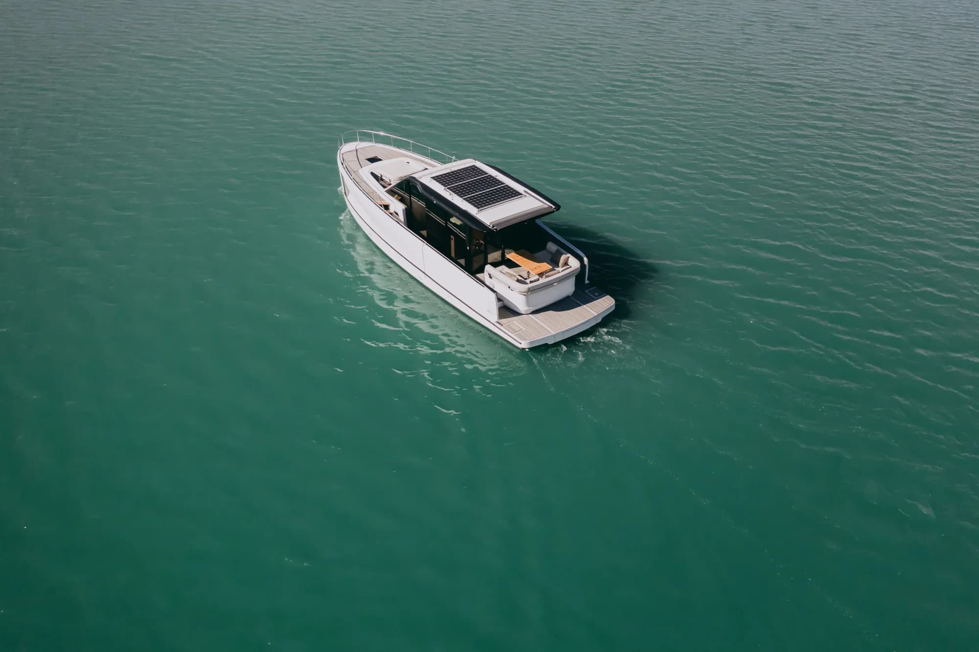 The white-hulled Wia 520 HardTop under way, its dark hardtop with roof solar panels over the enclosed saloon and teak decks.