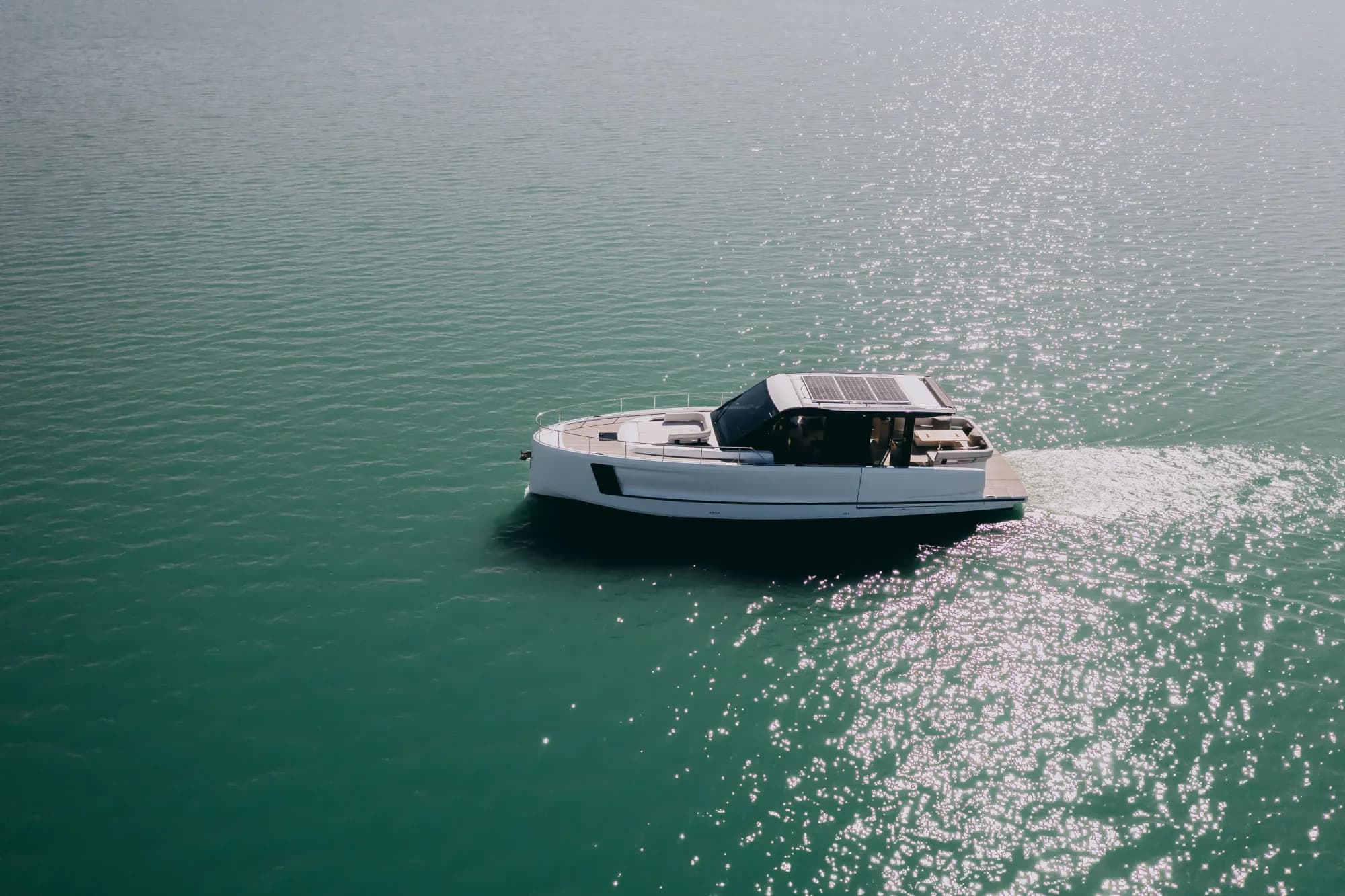 The white-hulled Wia 520 HardTop under way, its dark hardtop with roof solar panels over the enclosed saloon and teak decks.