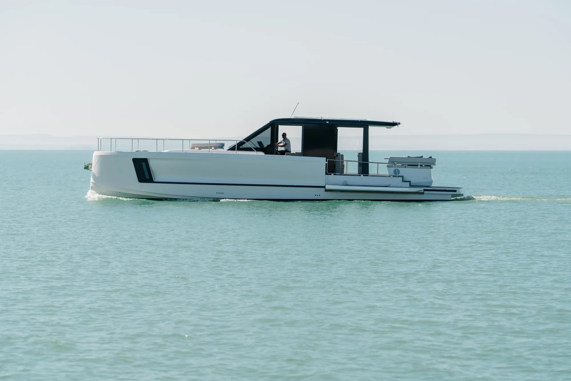 The white-hulled Wia 520 HardTop under way, its dark hardtop with roof solar panels over the enclosed saloon and teak decks.