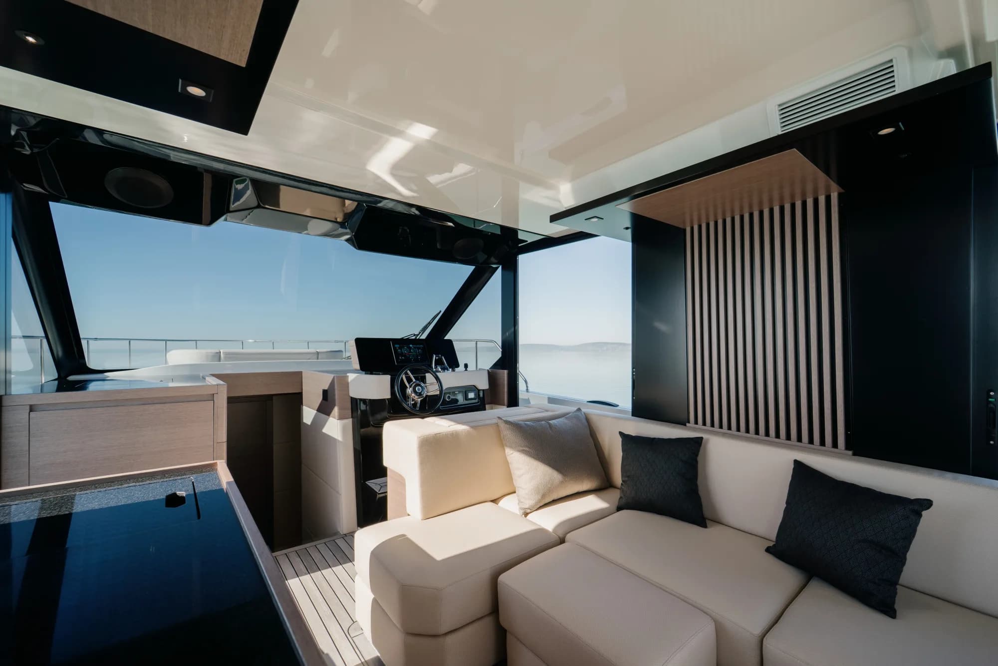 The saloon helm of the Wia 520 HardTop with a chrome-spoked wheel, touchscreen console and cream seating beneath the hardtop.