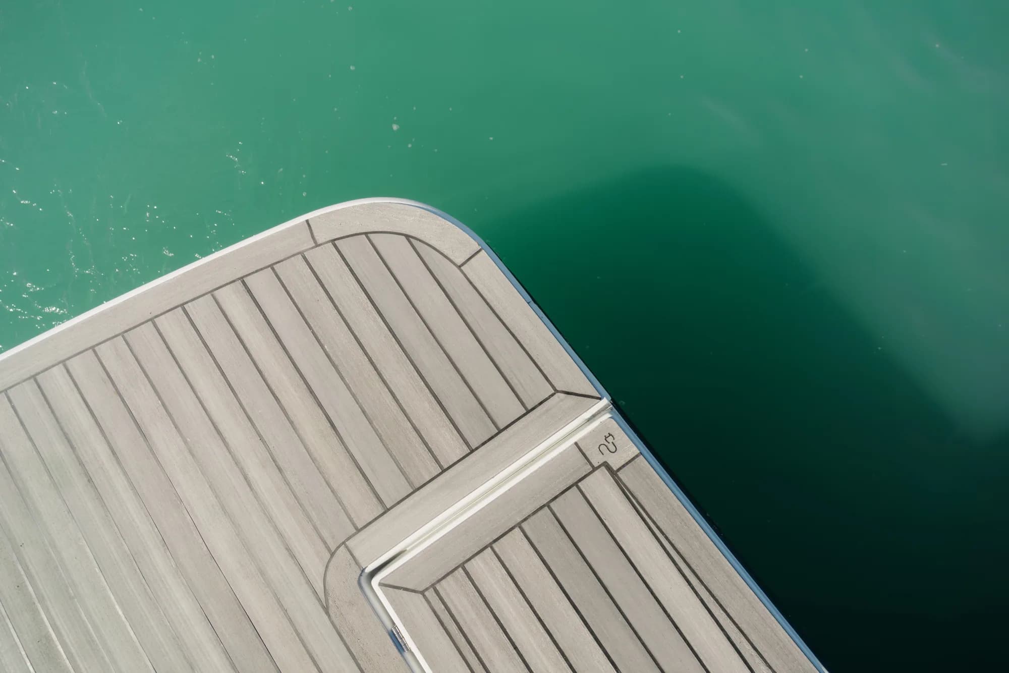 The teak deck of the Wia 520 HardTop with the open aft cockpit and cream seating.