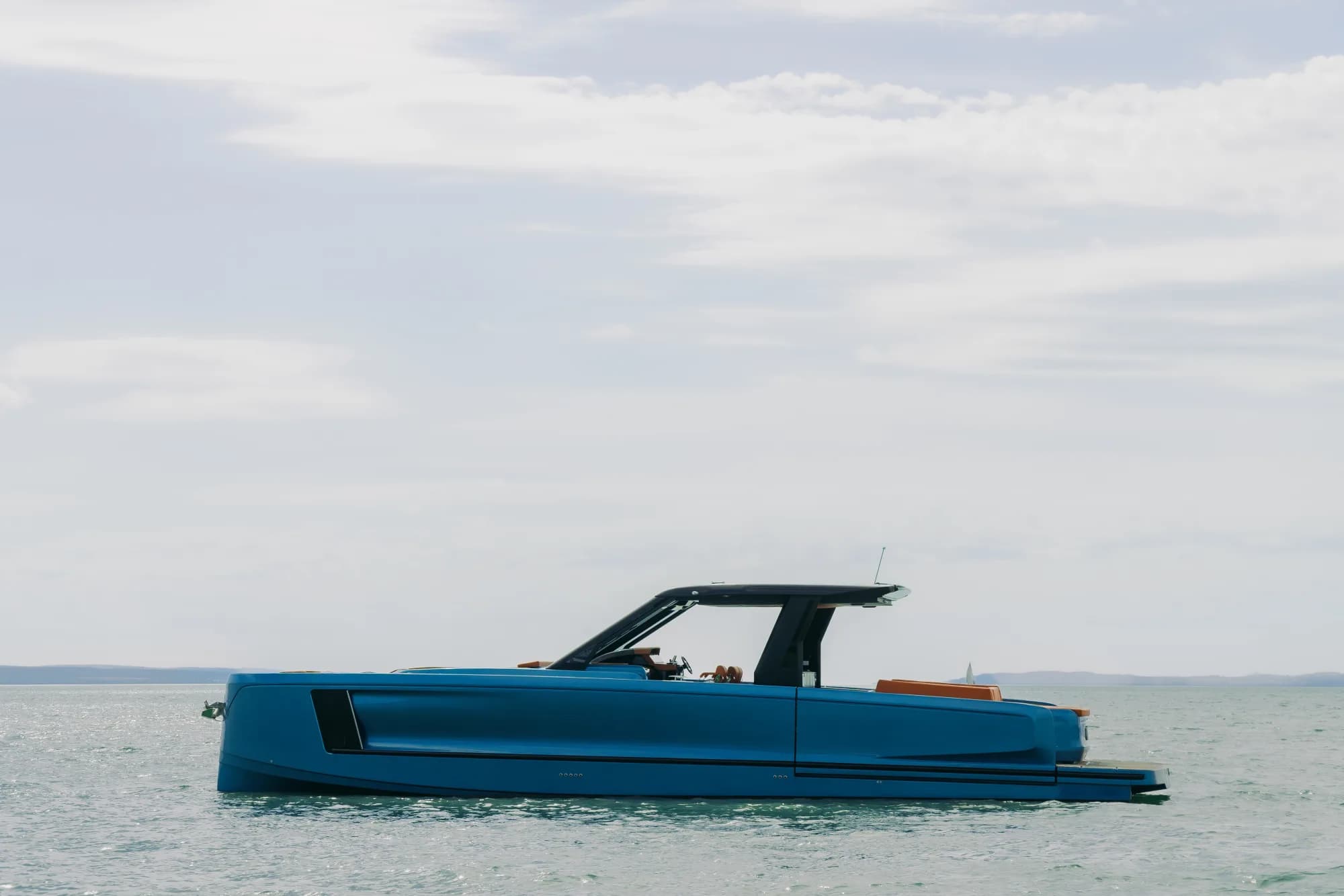 The Wia 520 Open under way, a clean wake trailing behind its blue hull on turquoise water.
