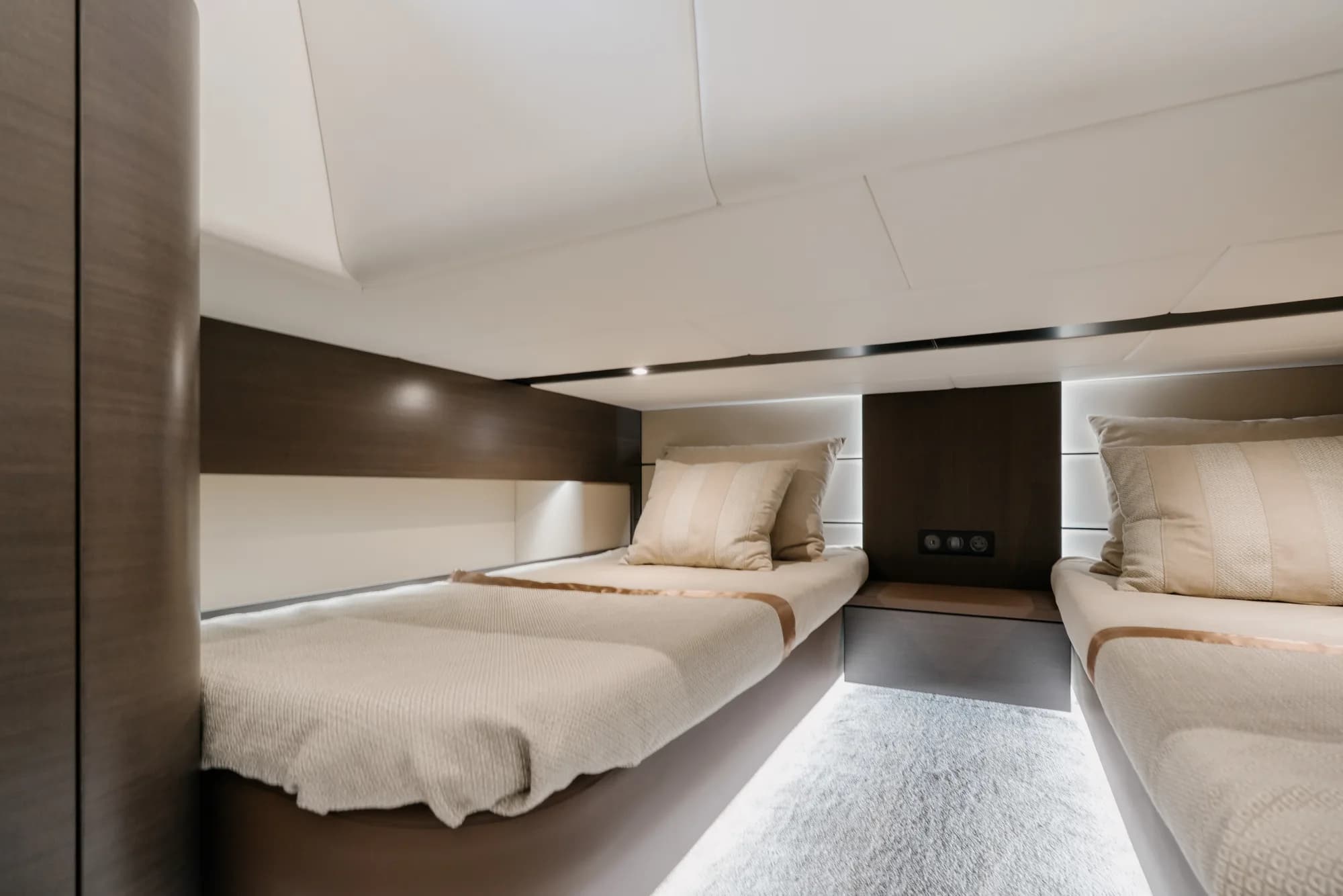 A guest cabin of the Wia 520 Open with cream bedding, pale oak panelling and natural light.