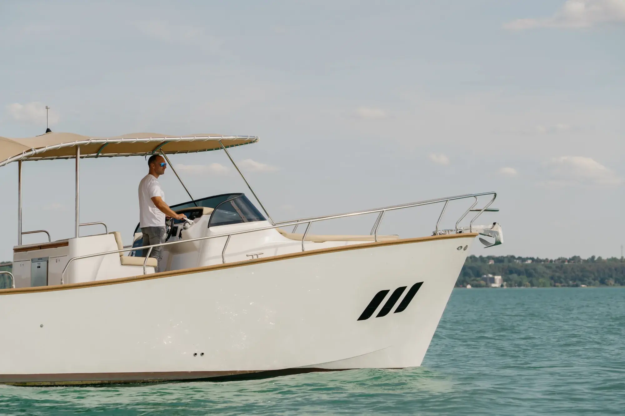 Der Wia 330 mit weißem Rumpf in Fahrt, das cremefarbene Verdeck über dem offenen Cockpit und der beigen Polsterung, mit Teak-Deckszier.