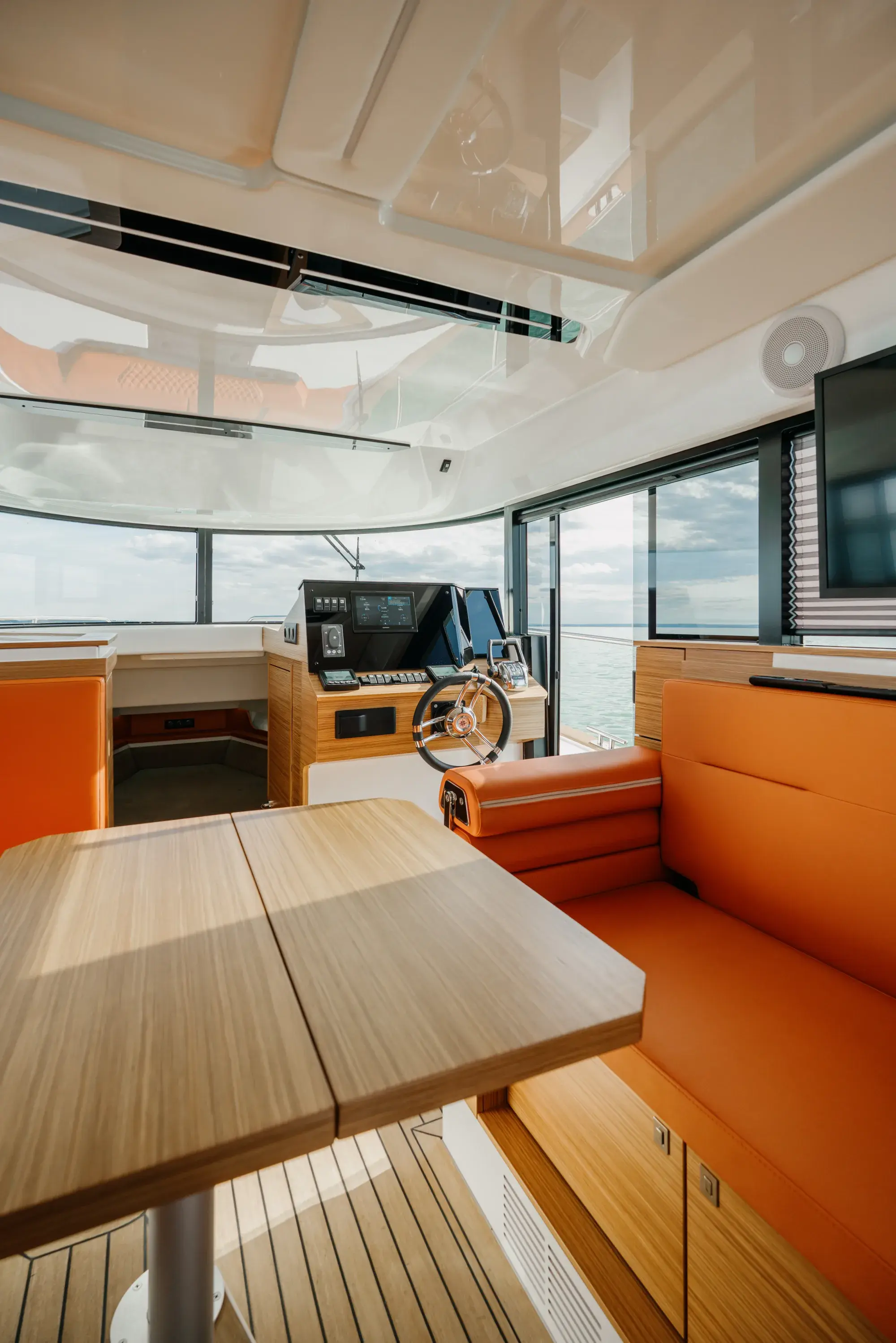Das Cockpit des Wia 350 mit orangefarbenen Ledersitzen, Teakdeck und dem geschlossenen Steuerstand voraus.
