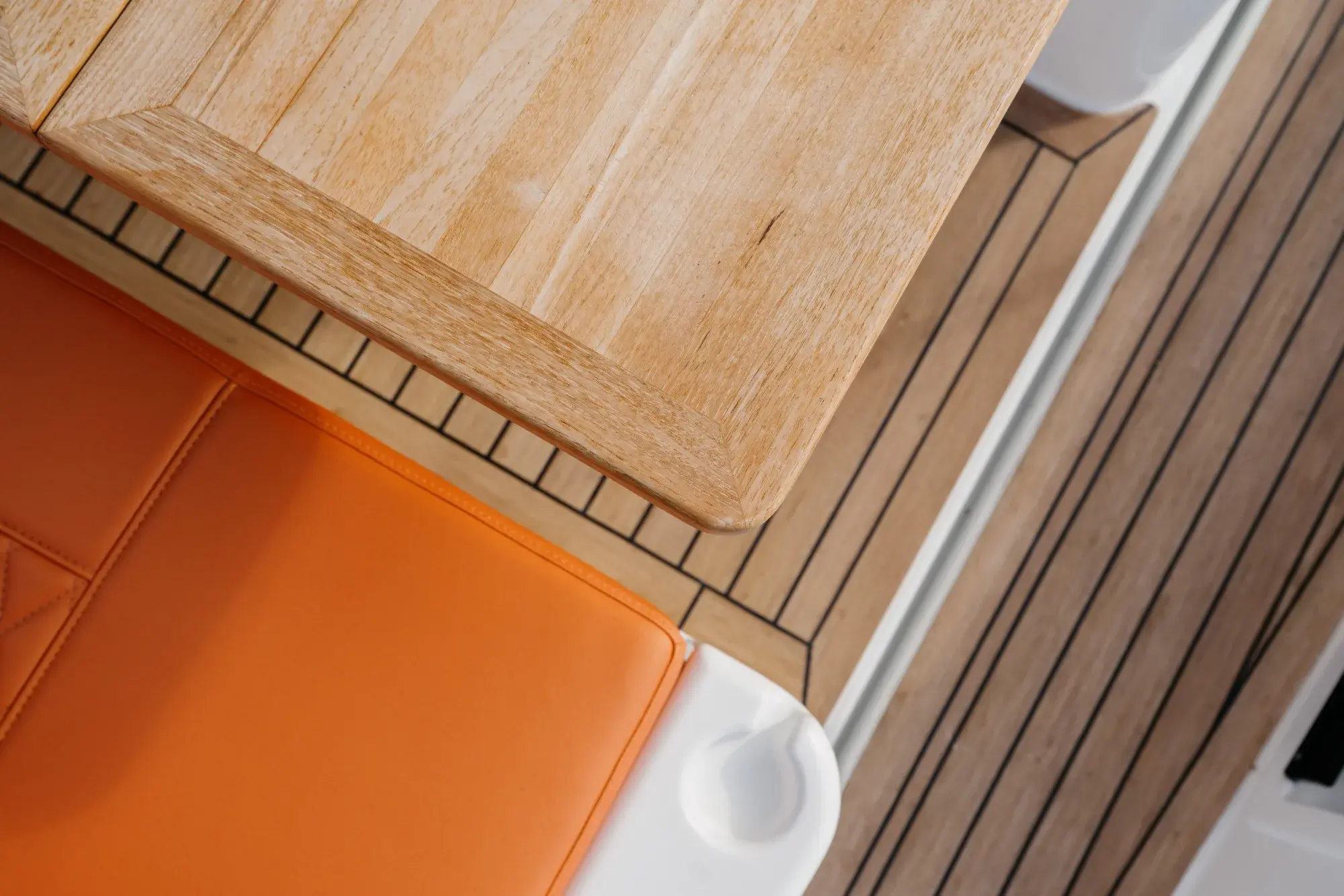 Das teakverzierte Deck des Wia 350 mit orangefarbenen Sonnenliegen und Edelstahlrelings.
