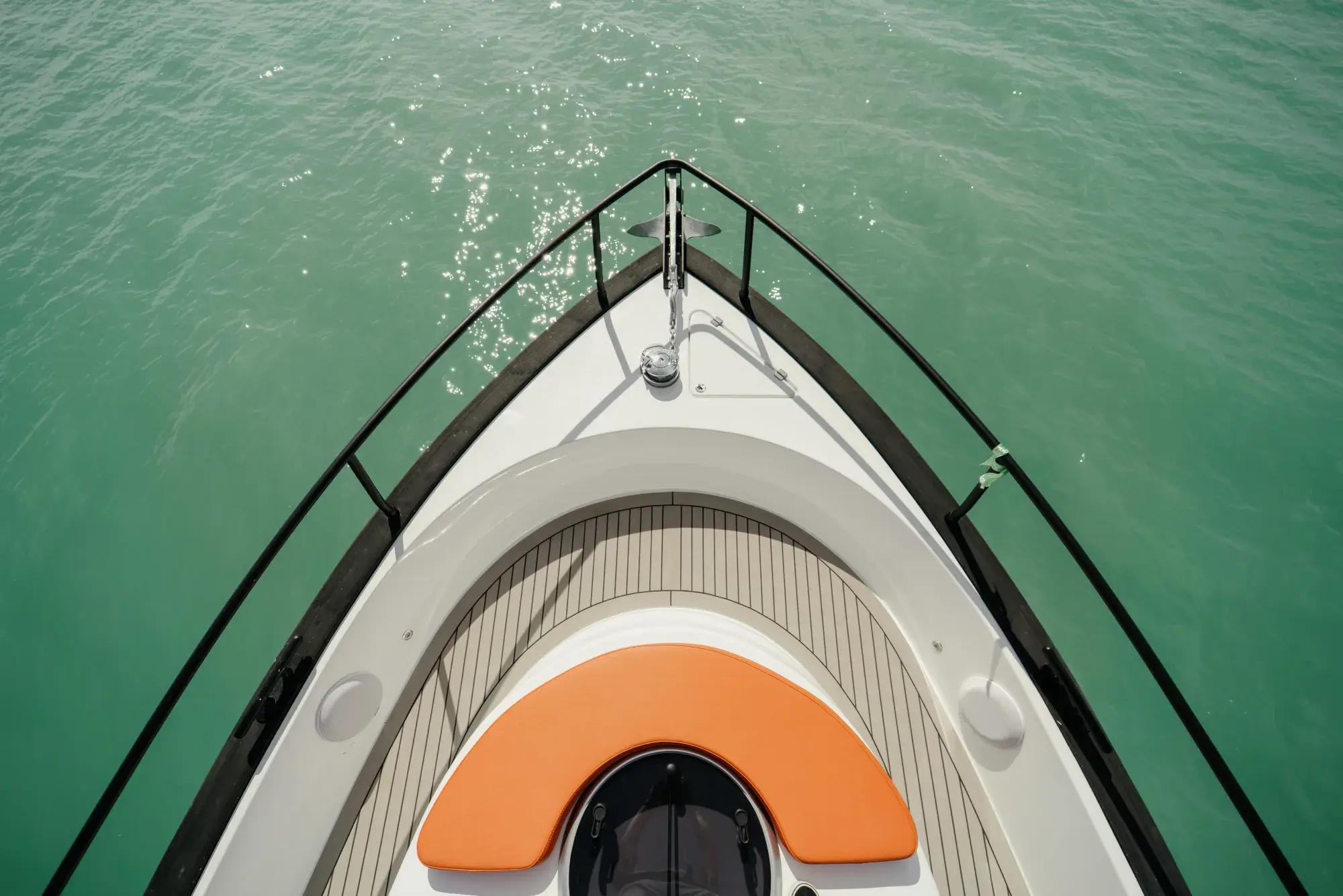 Le pont à liserés de teck de la Wia 450 HardTop avec bains de soleil orange et rambardes en inox.