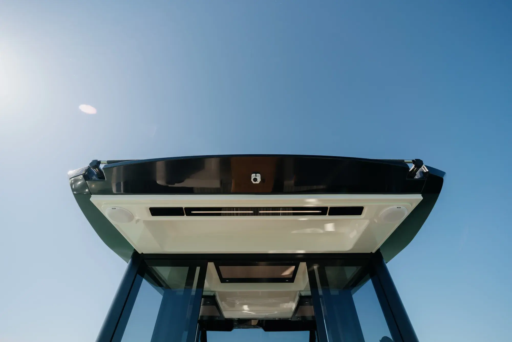 Die weiße Wia 520 HardTop in Fahrt, ihr dunkles Hardtop mit Dach-Solarmodulen über dem geschlossenen Salon und Teakdecks.