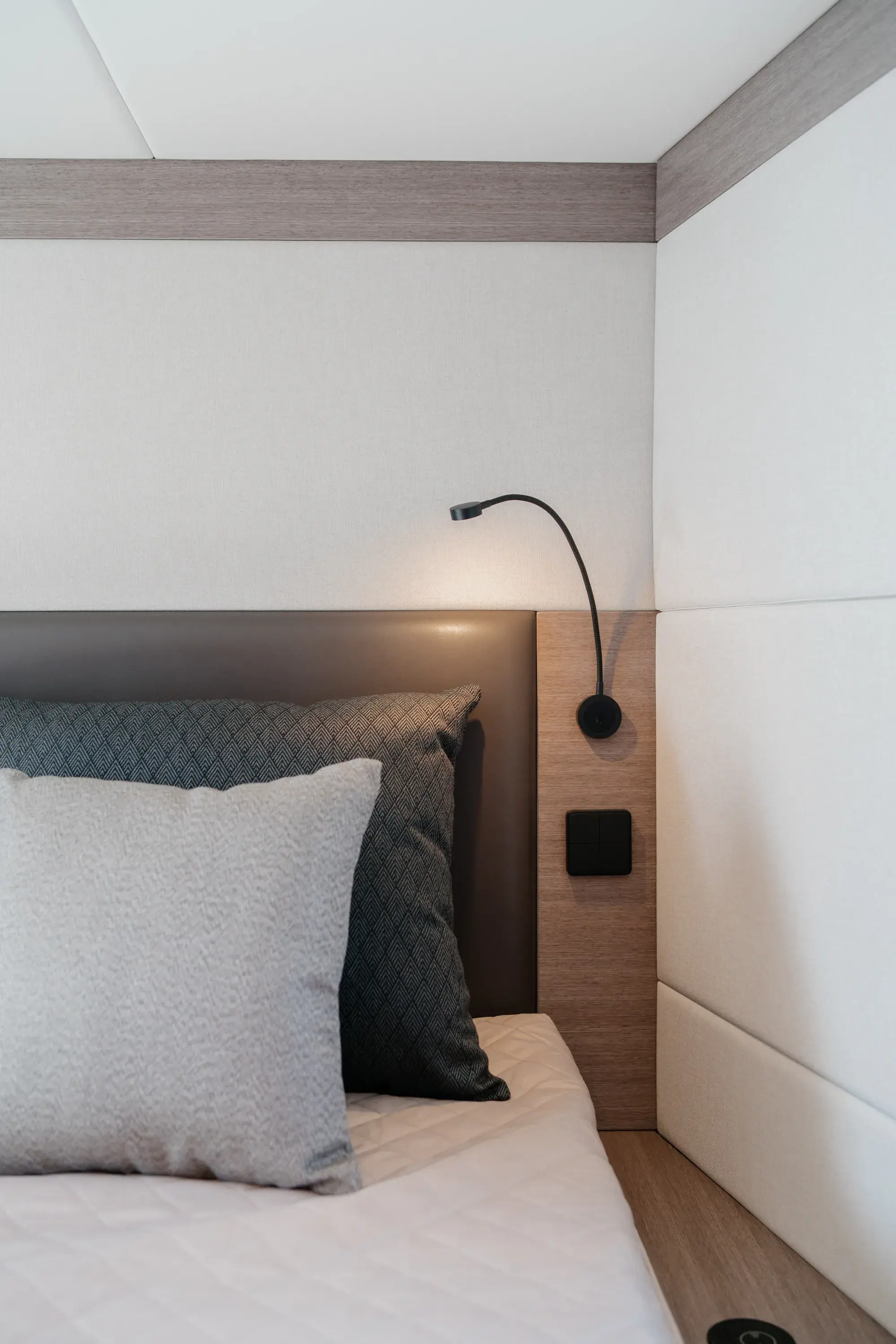 Une cabine de la Wia 520 HardTop en chêne clair, avec linge crème et douce lumière naturelle.
