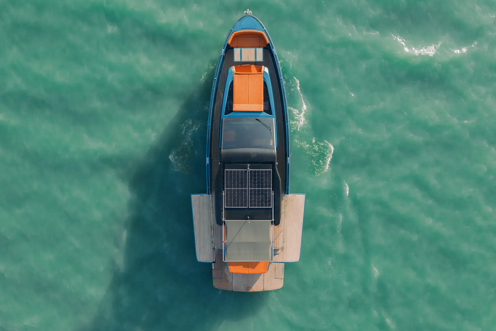 Die Wia 520 Open senkrecht von oben: Solarmodule auf dem Hardtop, orangefarbene Sonnenliegen und die Teak-Badeplattform.